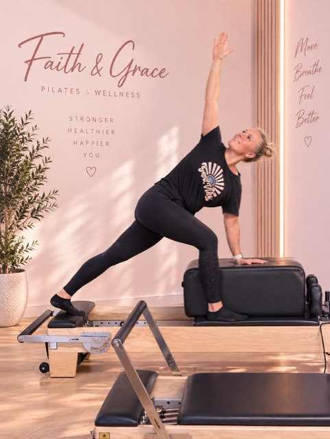 Jenelle performing a standing side stretch on the reformer in the Faith & Grace studio