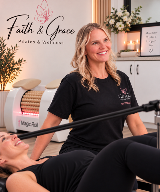 Jenelle smiling beside a client during a reformer session at the studio